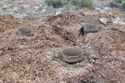 tri-pillar monument with 3 holes dug